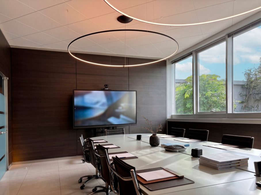 Air Control Lainate - Sala riunioni contemporanea con lampadari ad anello e boiserie scura